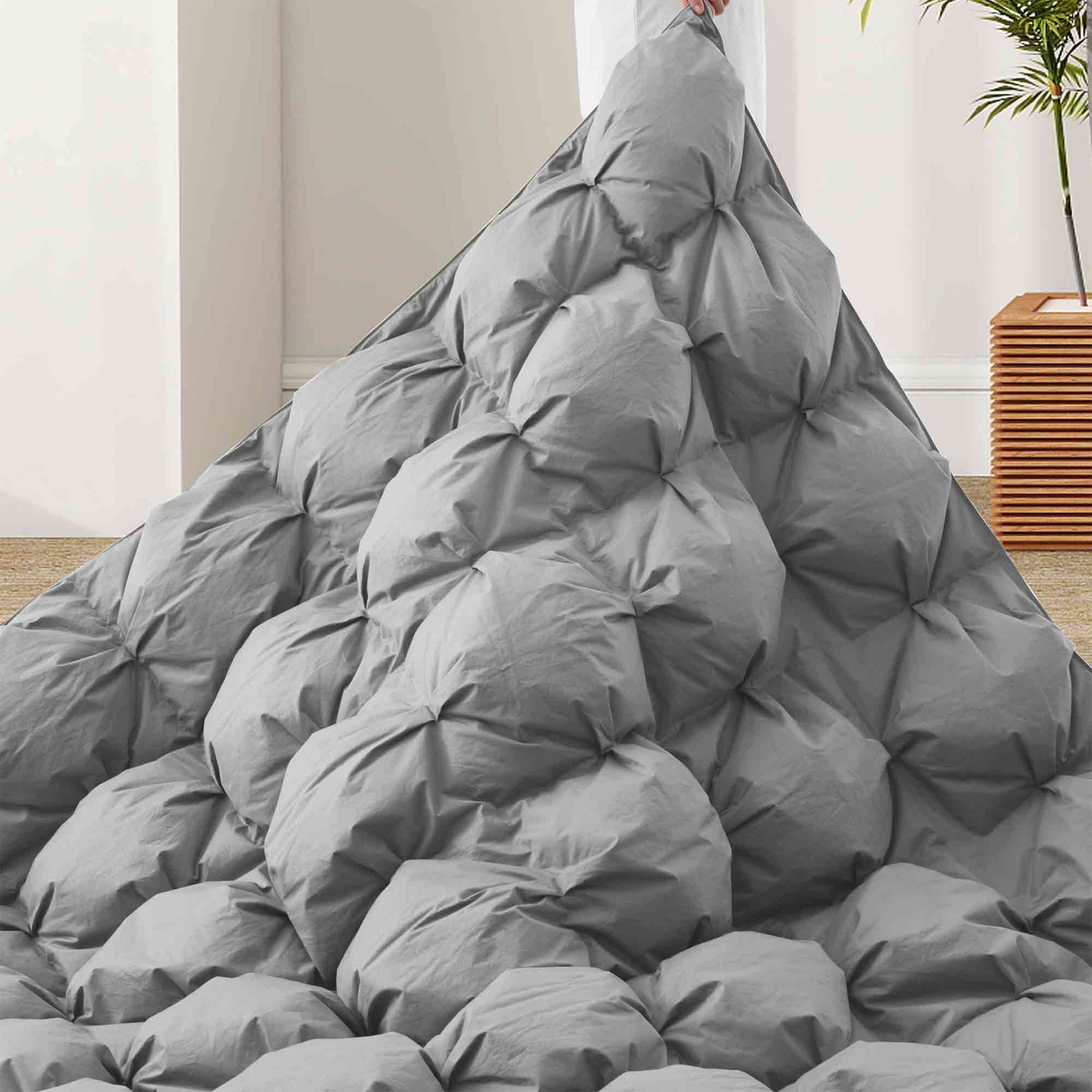 The medium warmth fluffy comforter is covered in the somber tones of gray. Add a touch of panache to your personal space with this high-quality all-season down comforter with corner taps for a snug sleep experience.