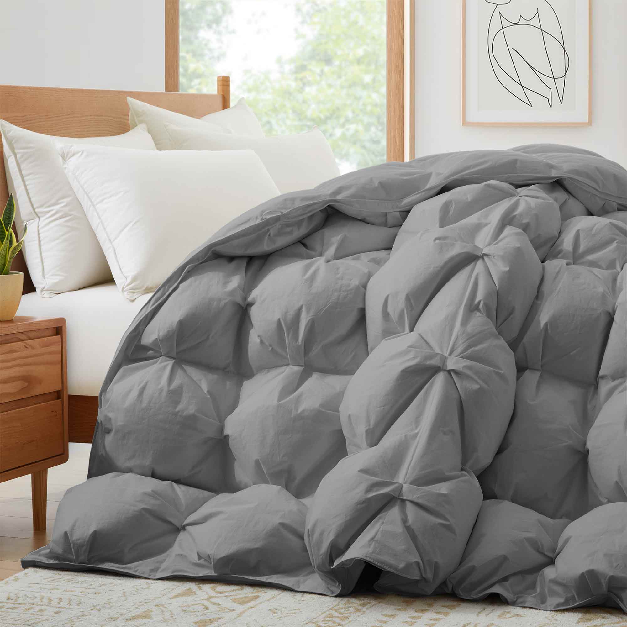 The medium warmth fluffy comforter is covered in the somber tones of gray. Add a touch of panache to your personal space with this high-quality all-season down comforter with corner taps for a snug sleep experience.