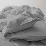 The medium warmth fluffy comforter is covered in the somber tones of gray. Add a touch of panache to your personal space with this high-quality all-season down comforter with corner taps for a snug sleep experience.