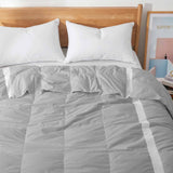 Ultra-lightweight cooling down comforter in gray, designed for breathable summer comfort with soft fabric and high down fill.