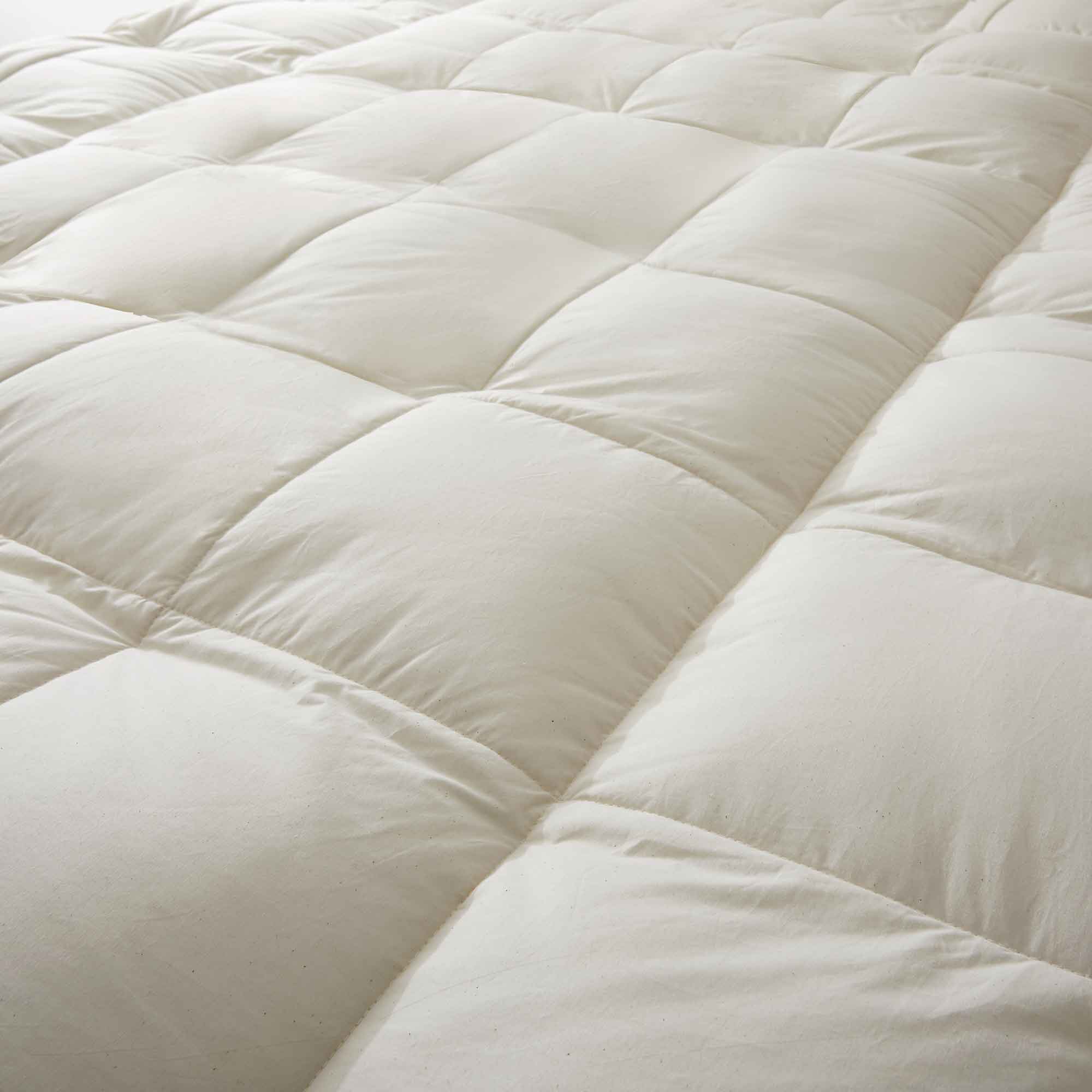 The plush surface of this feather blend mattress down topper is colored in pearly hues of off-white. Adding this feather mattress topper to your bedroom is an excellent choice for deep cushioning and additional comfort layer for a healthy sleep environment.