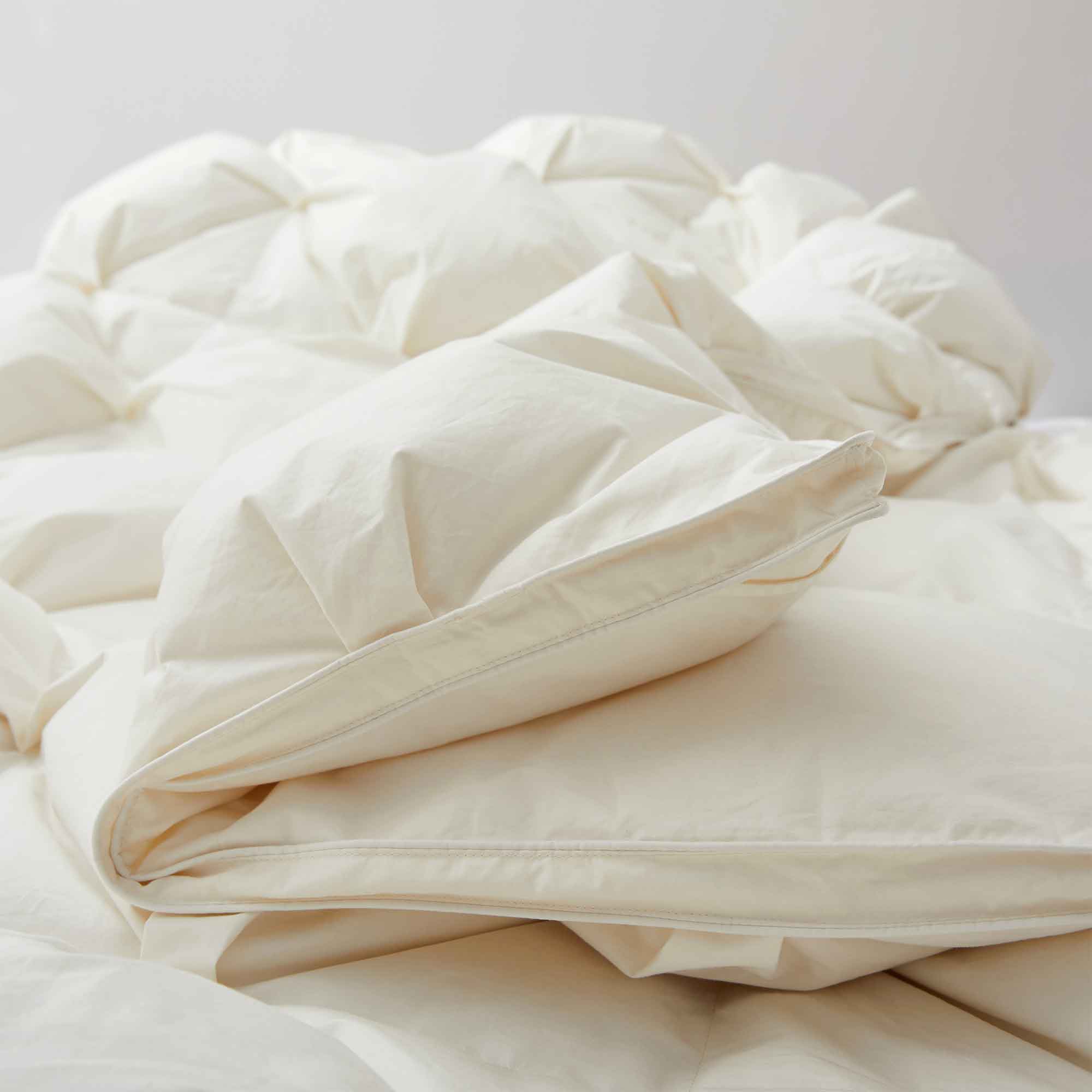 The down goose feather comforter is brushed in the pearly tones of off-white. Bring sophisticated elegance to your bedroom decor with this off-white bed comforter.