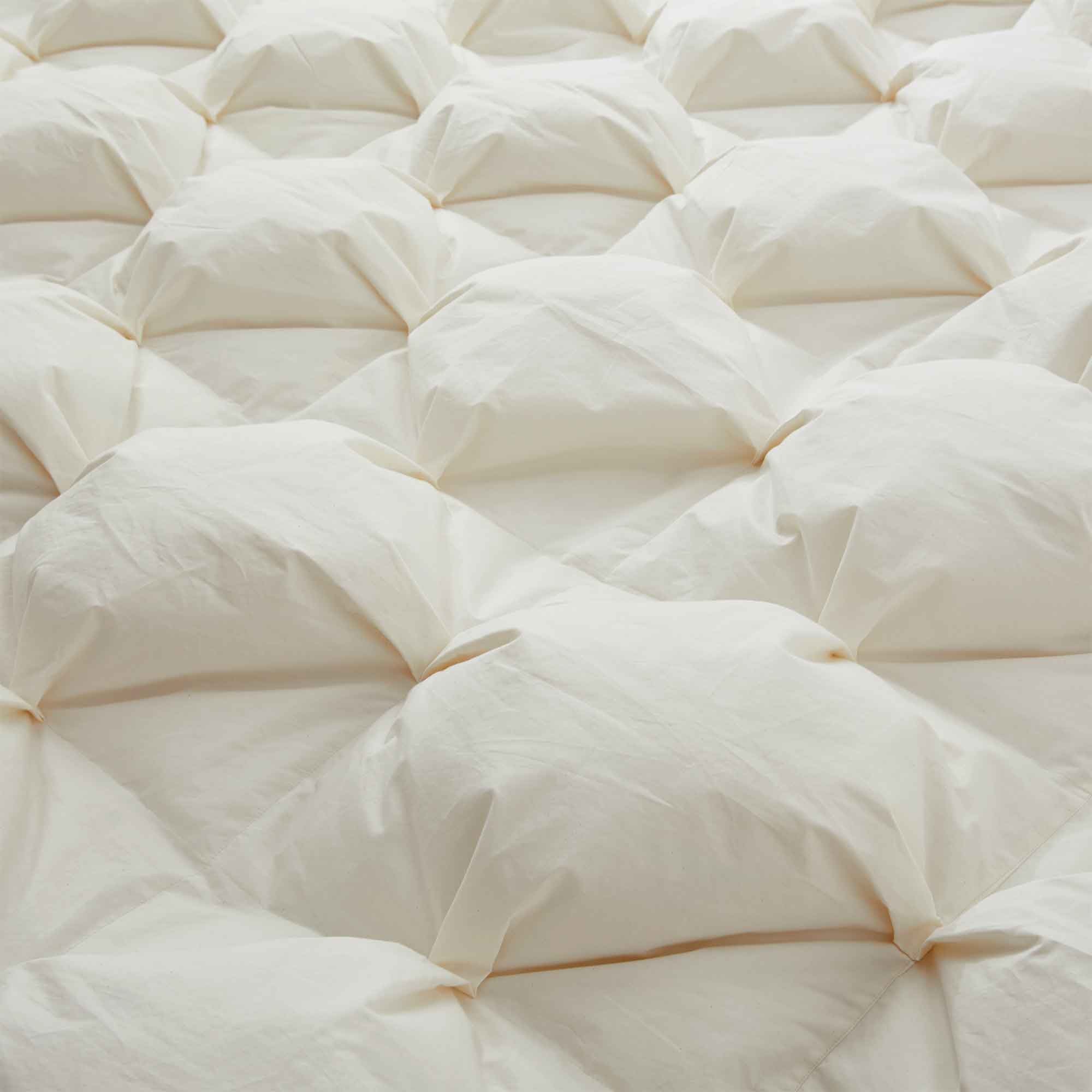 The down goose feather comforter is brushed in the pearly tones of off-white. Bring sophisticated elegance to your bedroom decor with this off-white bed comforter.