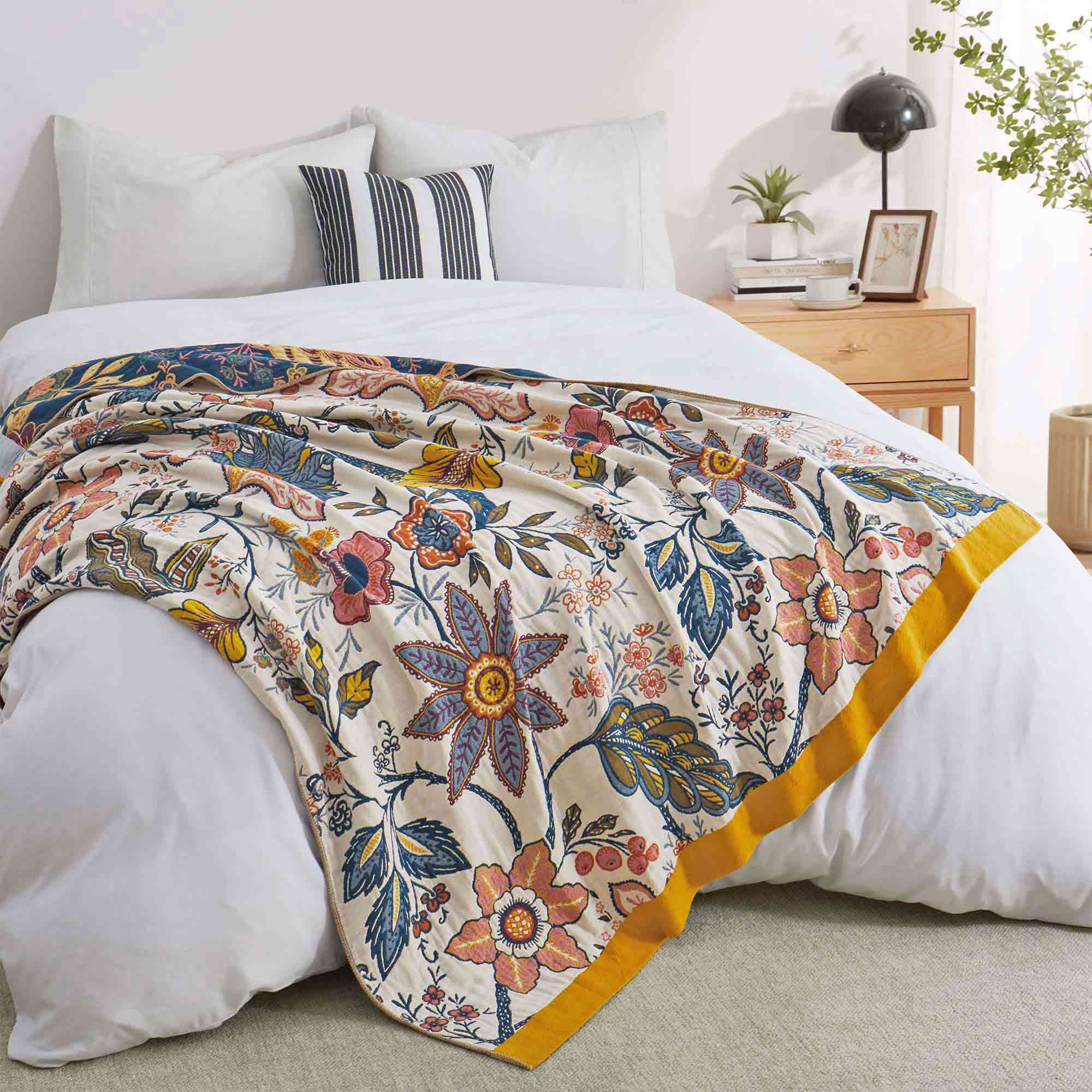 Cream-colored floral velvet throw blanket featuring vibrant red, blue, and yellow botanical patterns with a golden yellow border.