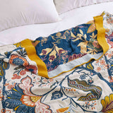 Cream-colored floral velvet throw blanket featuring vibrant red, blue, and yellow botanical patterns with a golden yellow border.