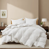 White comforter set on a bed in a bedroom with neutral walls and decor.