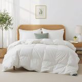 A neatly made bed with white bedding featuring the Organic Cotton Down Comforter, a green pillow, and a rattan headboard in a bright, cozy bedroom.