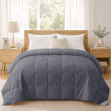 A neatly made bed with a gray comforter, white pillows, and light wood furniture features the Cotton Oversized Down Blanket, crafted from 380 thread count cotton, in a bright bedroom.