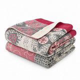 Two folded Boho Cotton Throw Blankets, featuring red, gray, and cream floral and leaf patterns, are stacked on a white background in a stylish multi-color design reminiscent of cotton jacquard.