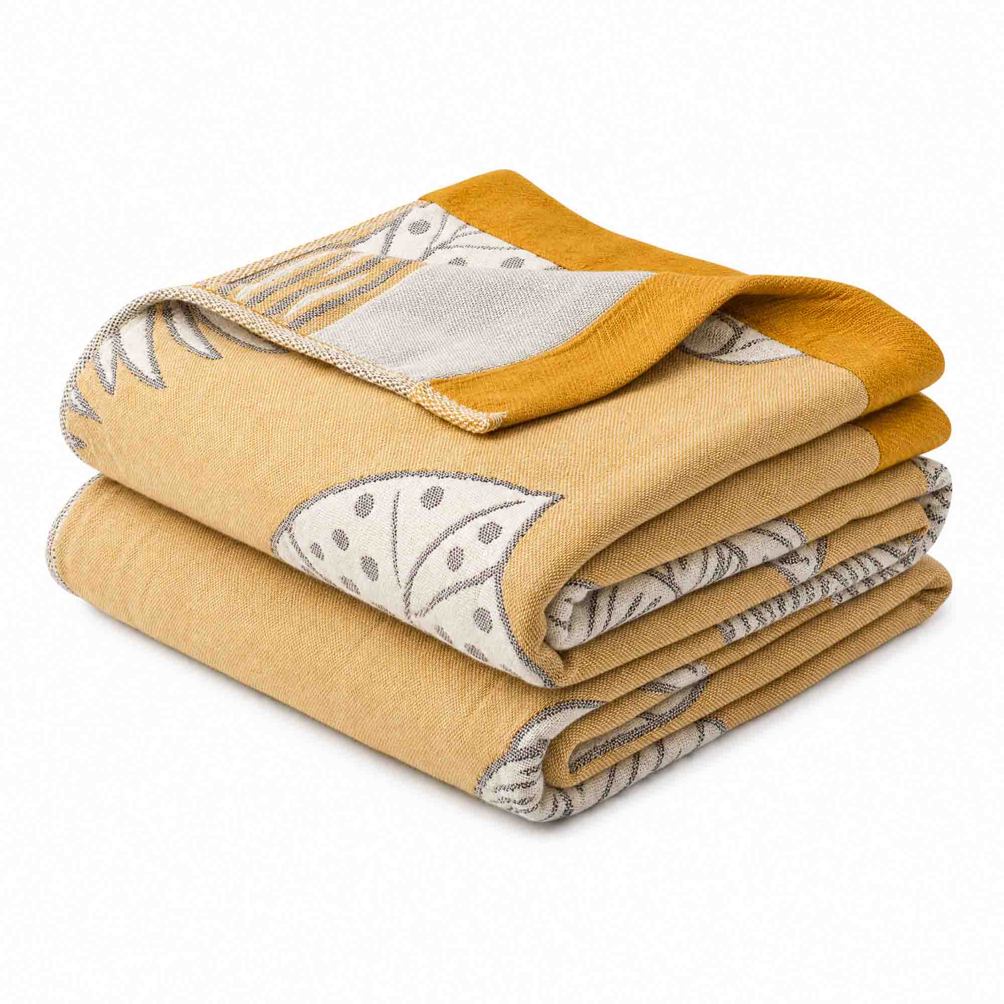 A folded Boho Cotton Throw Blanket in mustard yellow cotton jacquard, featuring a white and gray botanical pattern, displayed on a plain background—ideal for adding a stylish boho touch to your space.