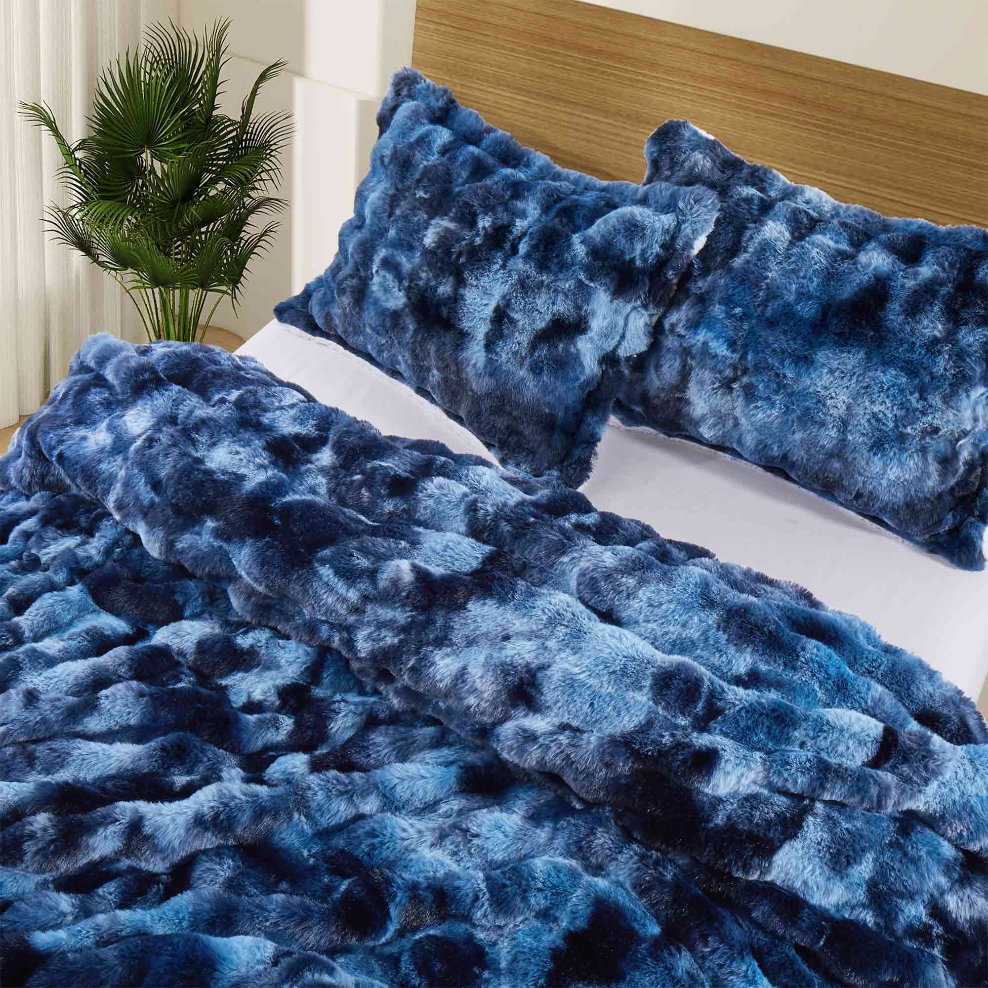 Navy faux rabbit fur comforter set featuring a reversible sherpa lining and pillow shams, adding a bold yet inviting touch to the bedroom.
