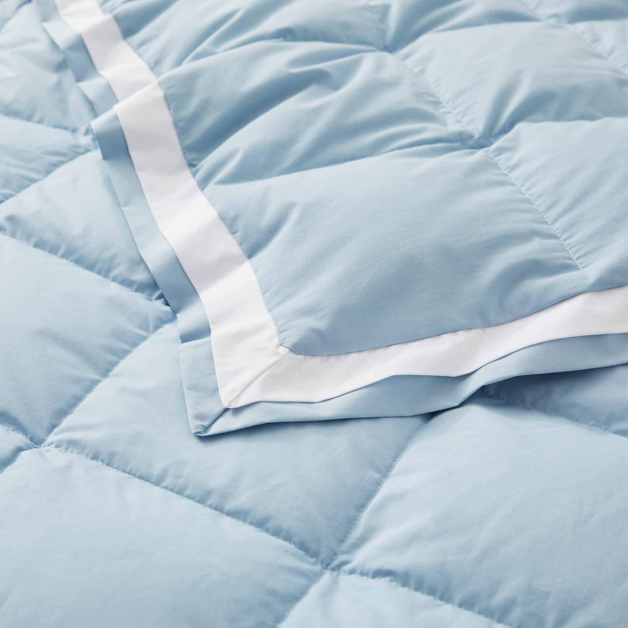 The feather down comforter blanket is enveloped in the airy tones of sky blue with a contrasting white trim. Enhance your bedding with the beauty of the skies with this summer season comforter in sky blue.