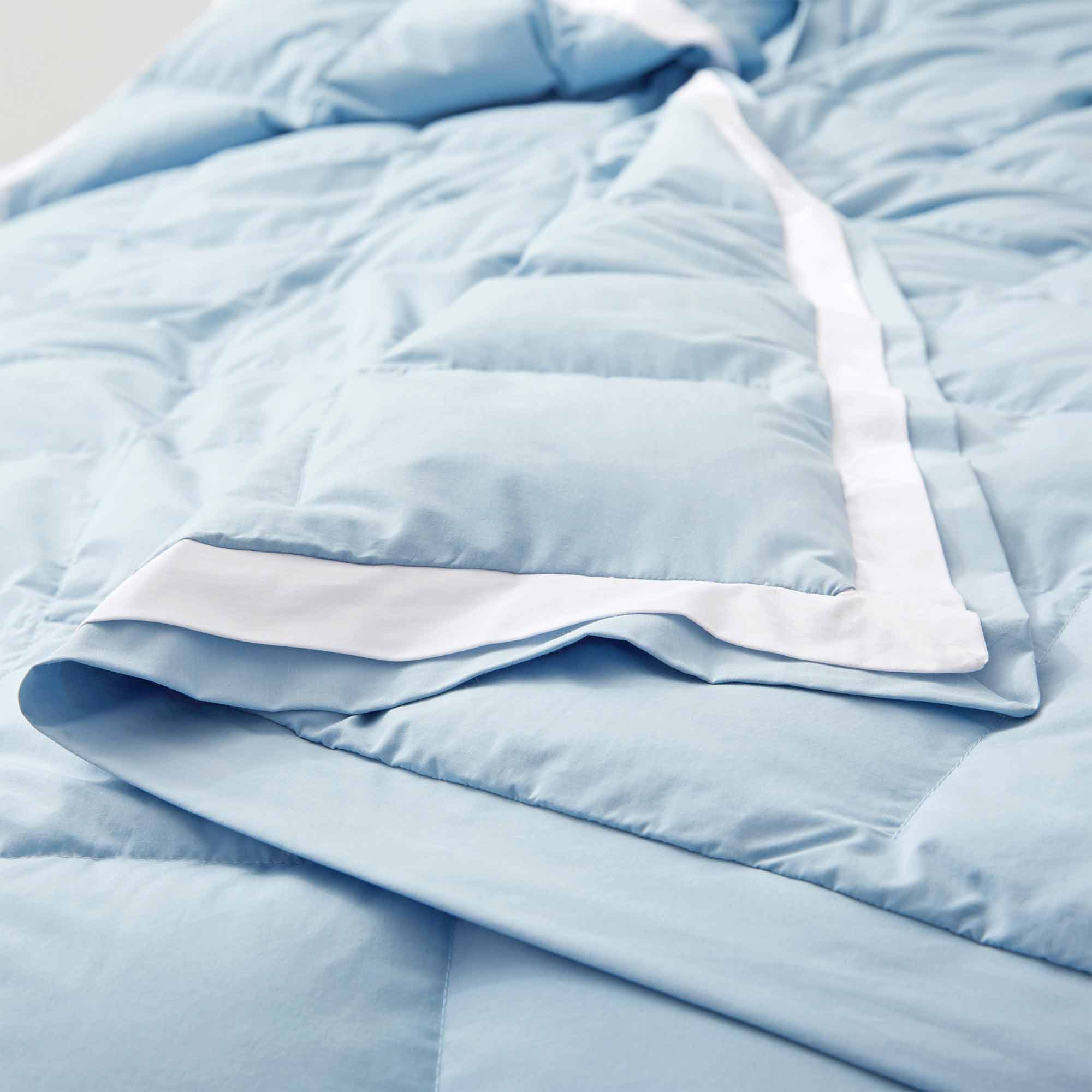 The feather down comforter blanket is enveloped in the airy tones of sky blue with a contrasting white trim. Enhance your bedding with the beauty of the skies with this summer season comforter in sky blue.