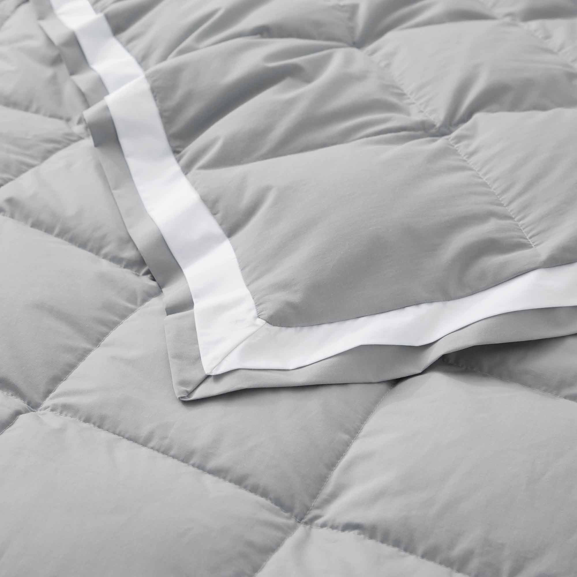 The summer cooling blanket is covered in the somber hues of gray with a complementing white trim. Bring refreshing sophistication to your personal space with this down duvet insert in gray.