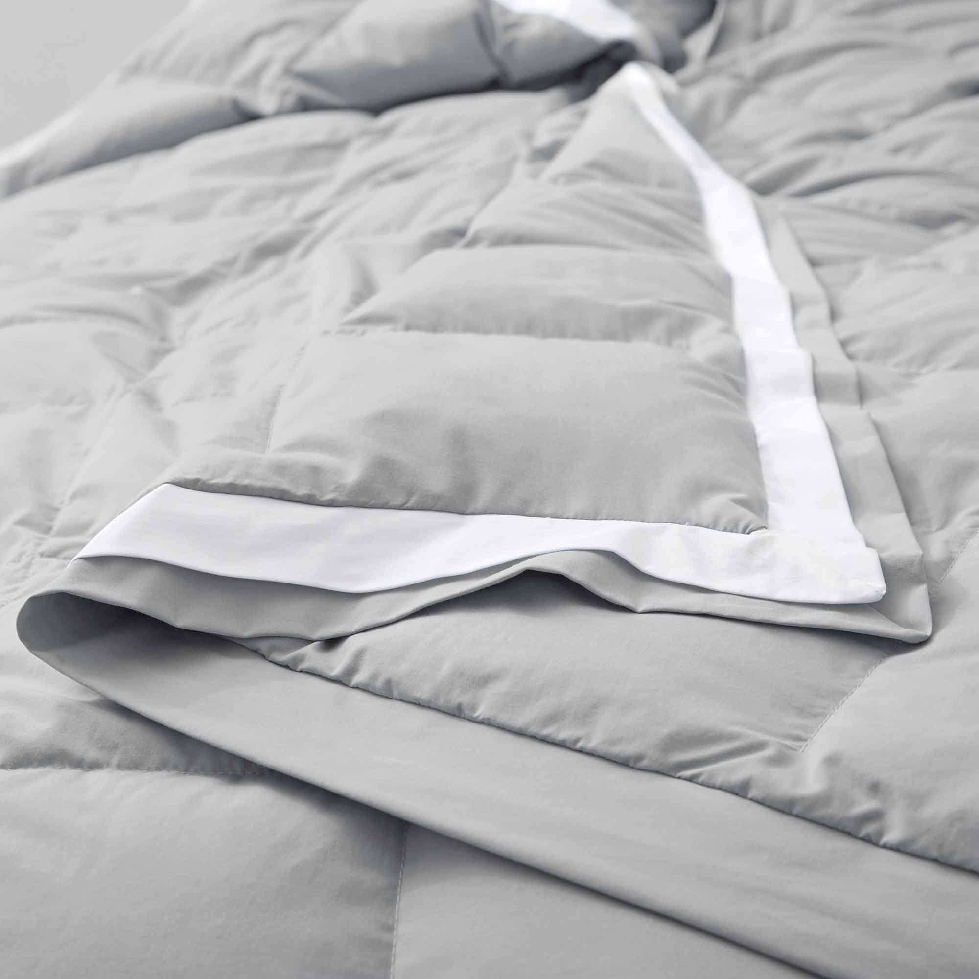 The summer cooling blanket is covered in the somber hues of gray with a complementing white trim. Bring refreshing sophistication to your personal space with this down duvet insert in gray.