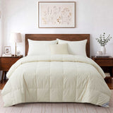 A neatly made bed featuring the Woven Stripe Down Blanket in cream, complemented by a wooden headboard, side tables, lamps, and botanical wall art above.