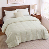 A neatly made bed with a Woven Stripe Down Blanket, wood headboard, and bedside tables in a bright bedroom.