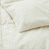 Woven Stripe Down Blanket in a cream color with stripes, elegantly displayed on a neatly made bed.