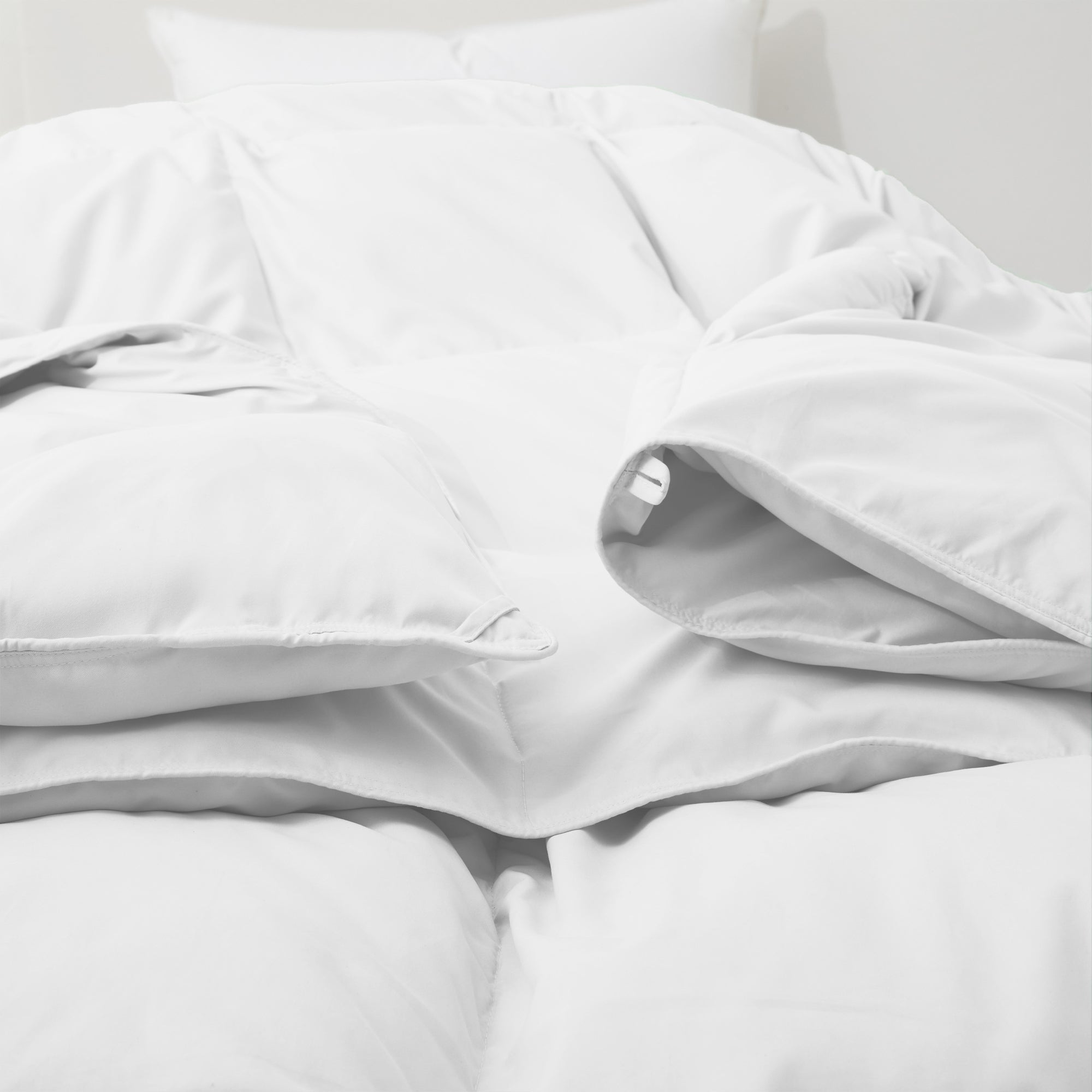 Fresh white tones are brushed over the all-size comforter. Add a touch of all-around luxurious warmth to your modern bedroom design with this down comforter with feathers.
