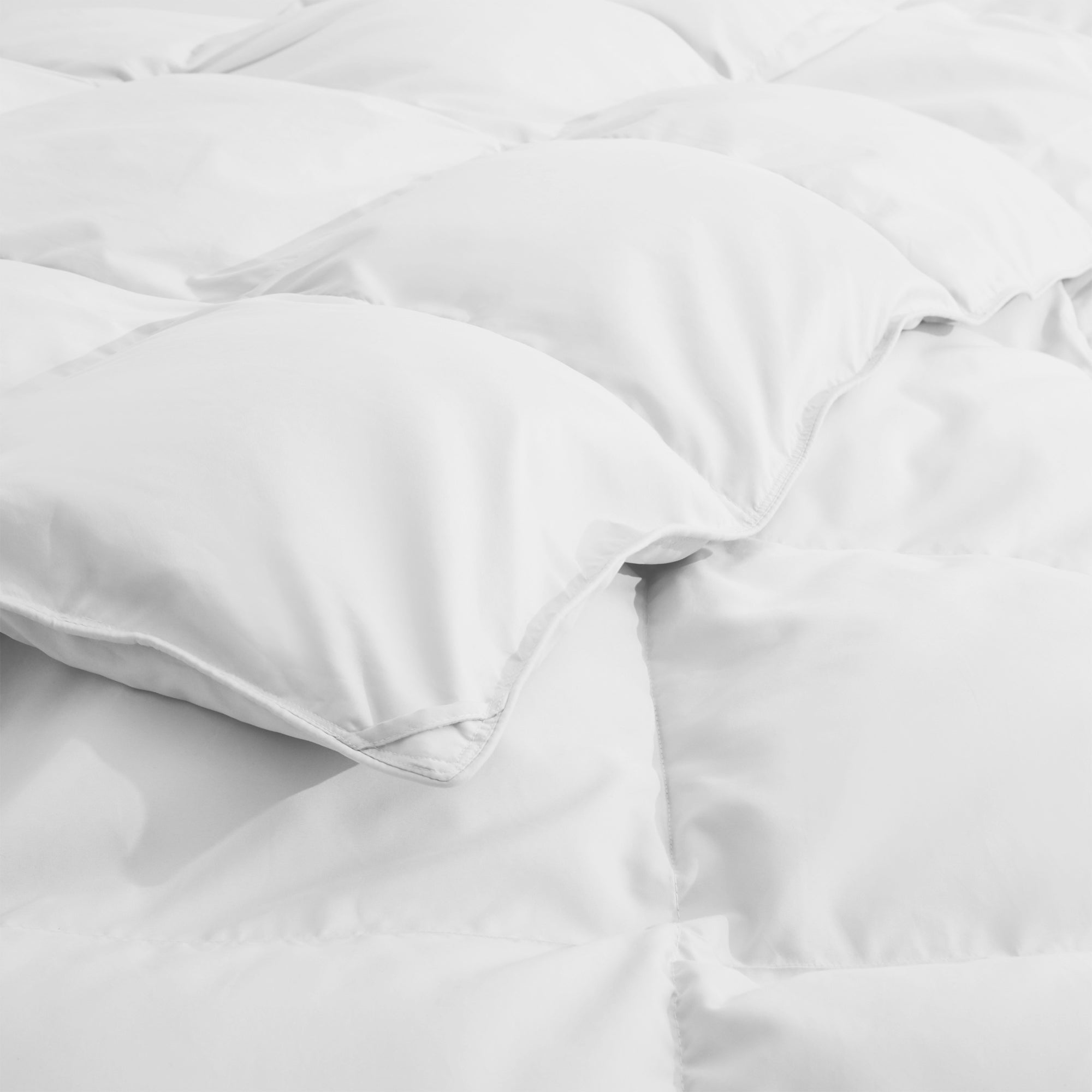 Fresh white tones are brushed over the all-size comforter. Add a touch of all-around luxurious warmth to your modern bedroom design with this down comforter with feathers.