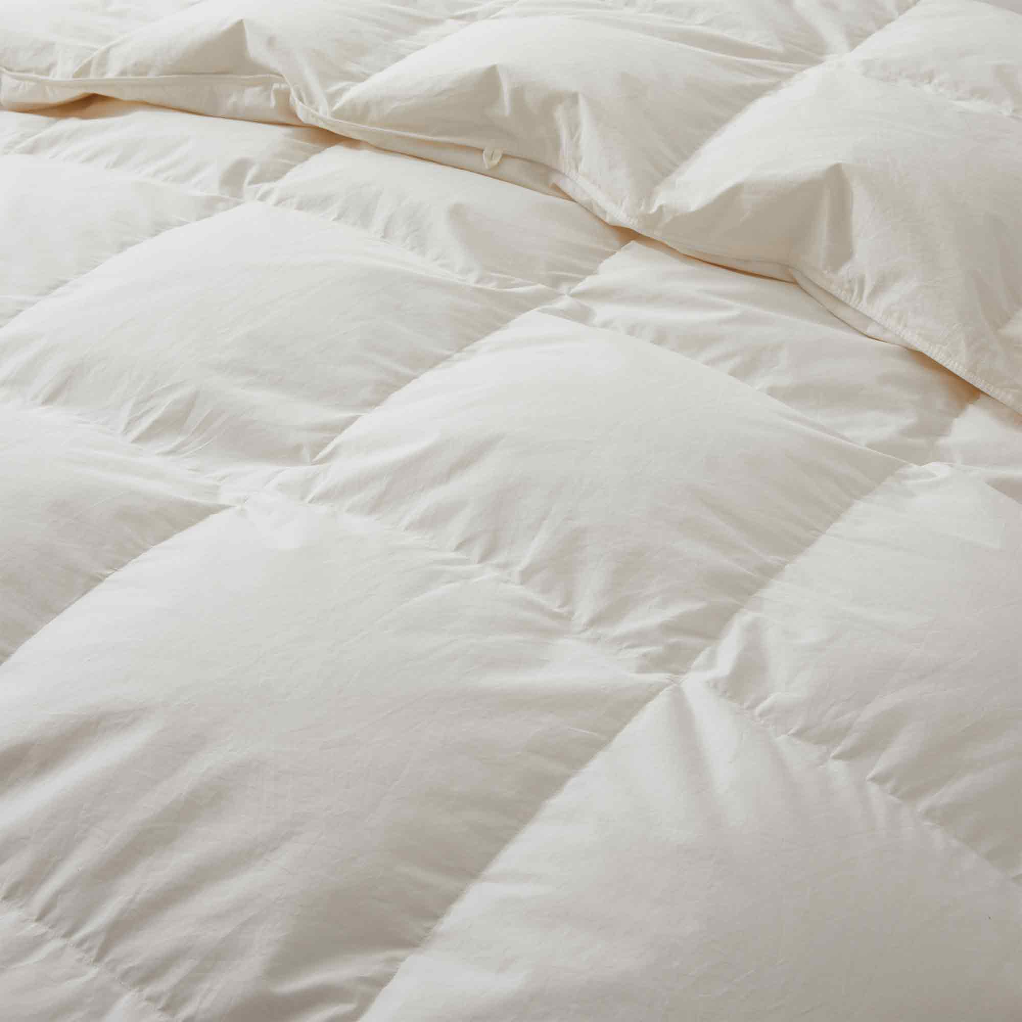 Crafted with a 100% organic cotton shell and filled with 90% natural white down, this comforter offers superior warmth and breathability. Its 800 fill power ensures a lightweight yet insulating sleep experience. Designed for year-round comfort, it features baffle box construction to maintain even fill distribution. Available in all-season and extra warm options, this comforter combines eco-friendly materials with luxurious softness for a restful night's sleep.
