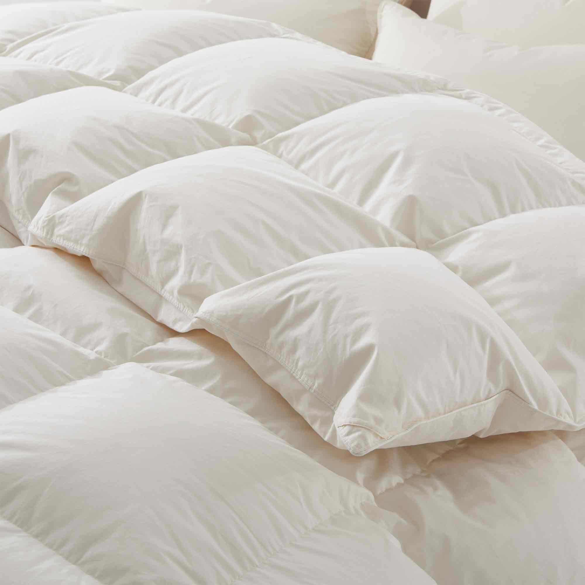 Crafted with a 100% organic cotton shell and filled with 90% natural white down, this comforter offers superior warmth and breathability. Its 800 fill power ensures a lightweight yet insulating sleep experience. Designed for year-round comfort, it features baffle box construction to maintain even fill distribution. Available in all-season and extra warm options, this comforter combines eco-friendly materials with luxurious softness for a restful night's sleep.
