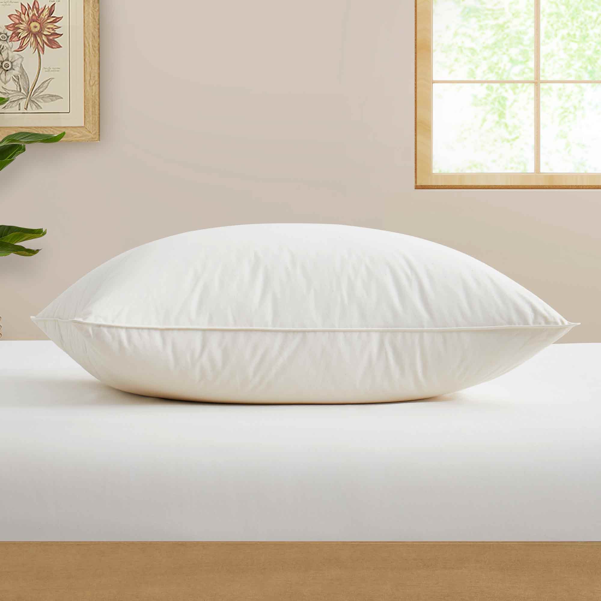 The fluffier pillow is covered in soft hues of off-white. Sink in the plush support and comfort of these best down pillows.