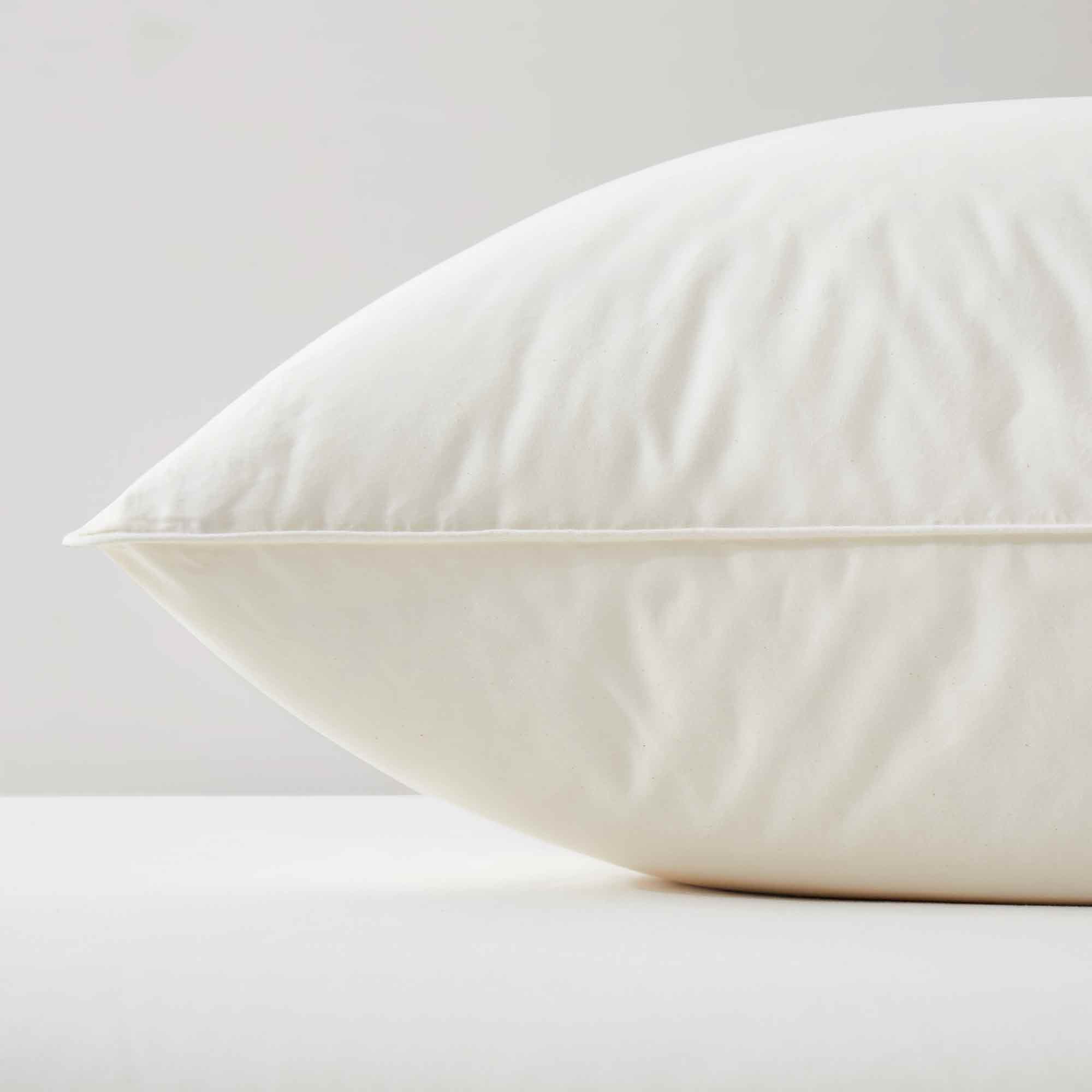 The fluffier pillow is covered in soft hues of off-white. Sink in the plush support and comfort of these best down pillows.
