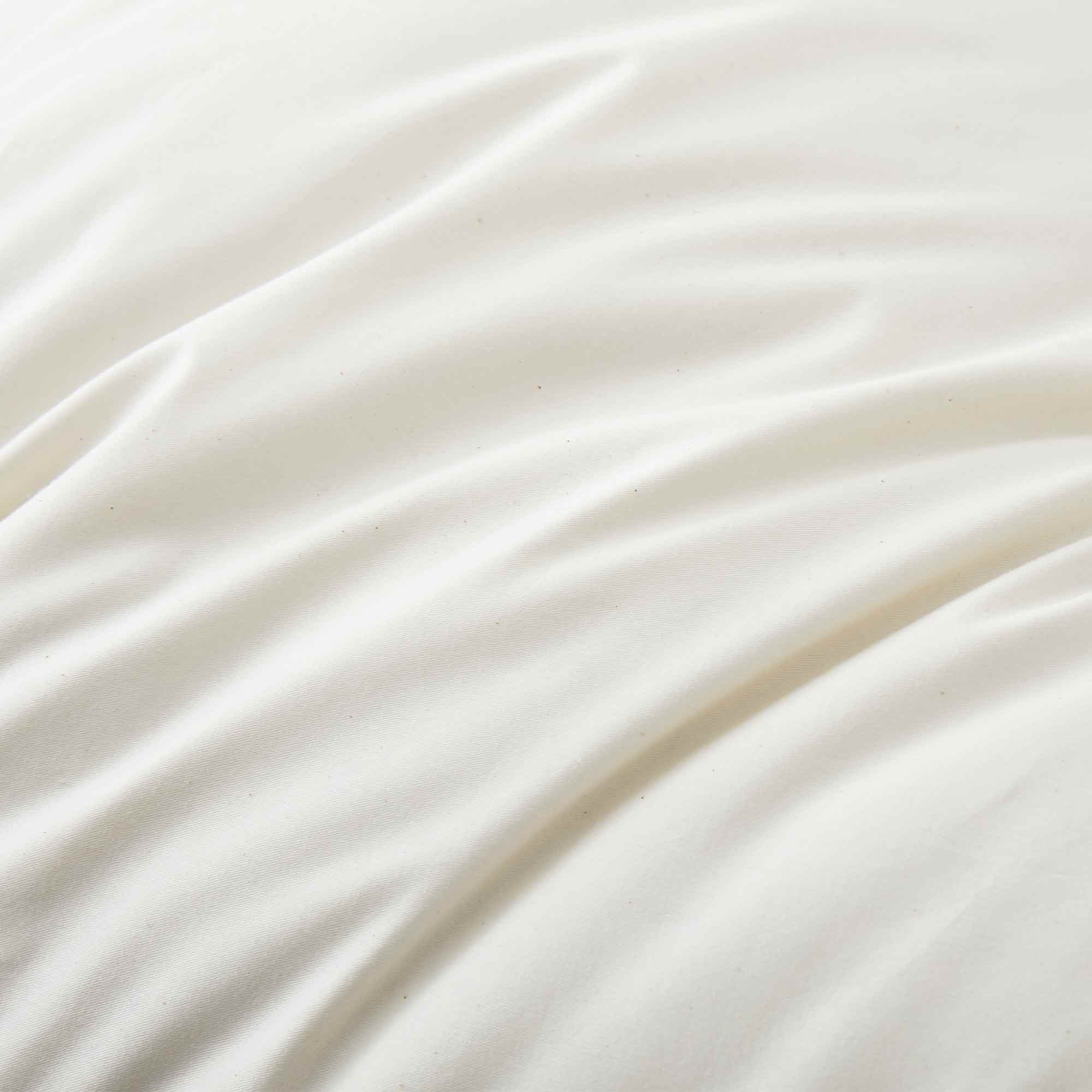 The fluffier pillow is covered in soft hues of off-white. Sink in the plush support and comfort of these best down pillows.
