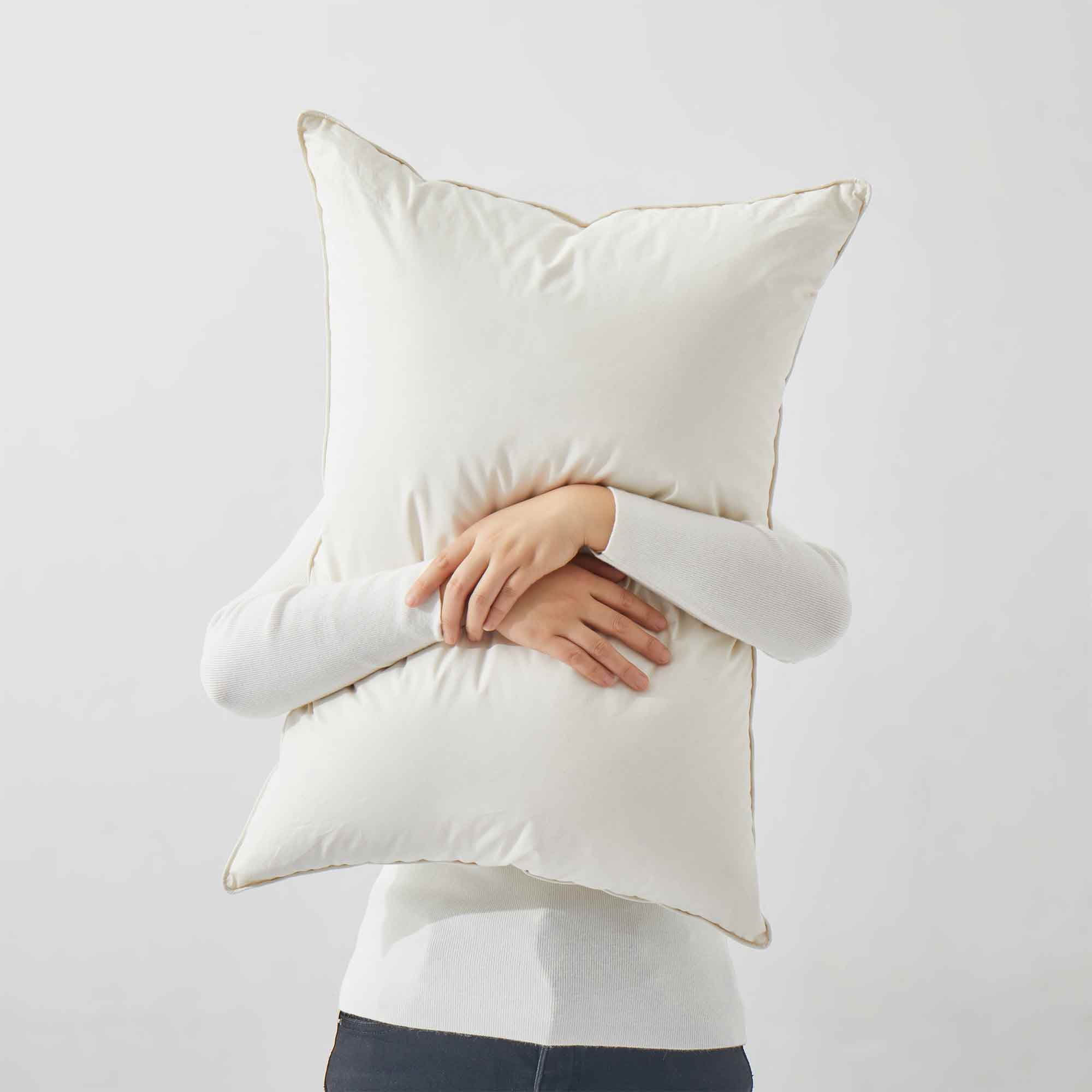 The fluffier pillow is covered in soft hues of off-white. Sink in the plush support and comfort of these best down pillows.