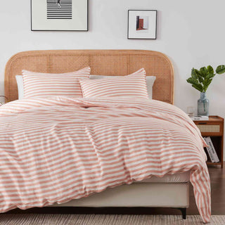 The designer bedding set is covered in alternating white and coral stripes. Elevate your bedroom decor with our duvet cover set featuring vibrant coral stripes for a bold and stylish statement.