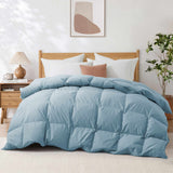 A neatly made bed featuring the Premium Goose Feather Comforter in blue, paired with white pillows, a nightstand, and a plant beside it.