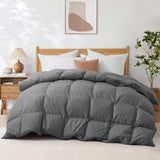 A neatly made bed featuring the Premium Goose Feather Comforter in gray, styled with white pillows and a beige pillow, creates a cozy, modern bedroom atmosphere.