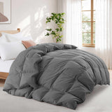 A Premium Goose Feather Comforter on a bed in a bright bedroom with a plant, window, and white curtains.