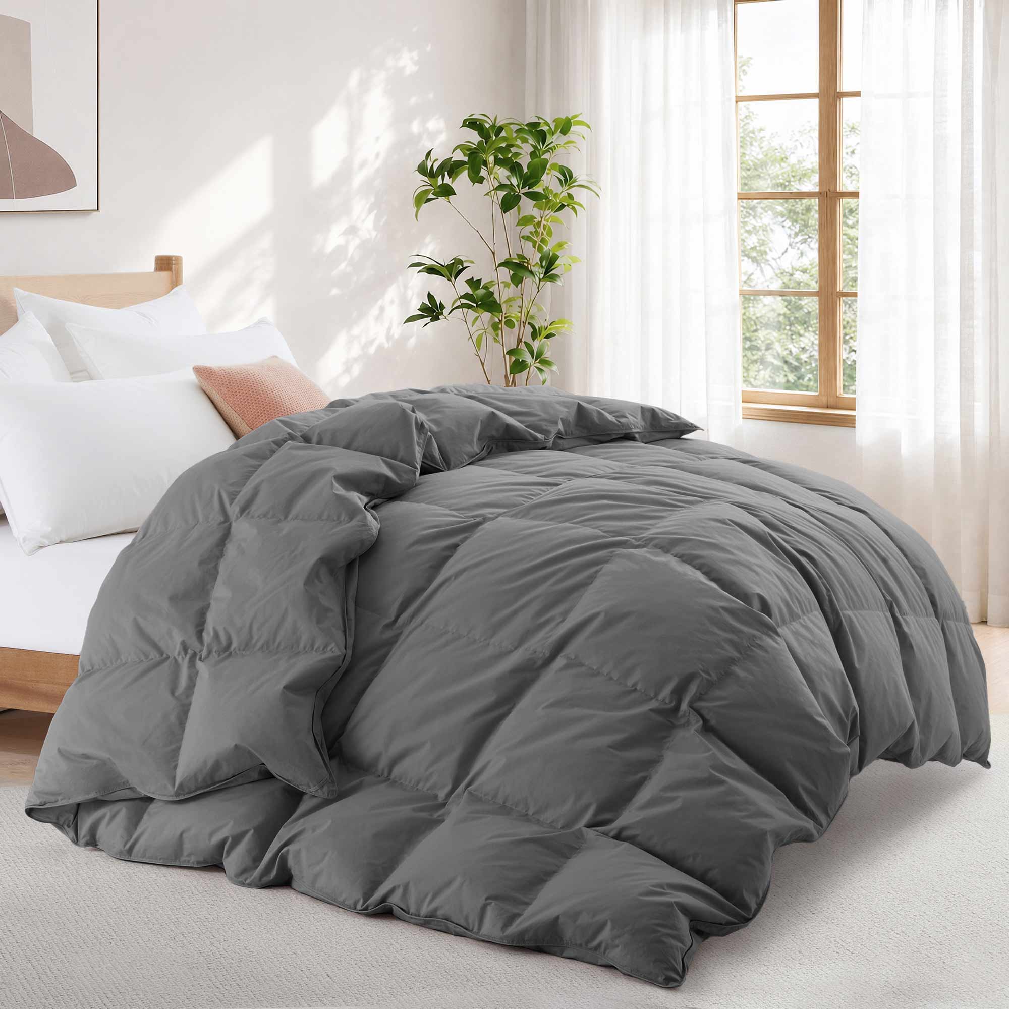 A Premium Goose Feather Comforter on a bed in a bright bedroom with a plant, window, and white curtains.