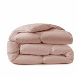 A Premium Goose Feather Comforter in light pink, neatly folded against a white background.