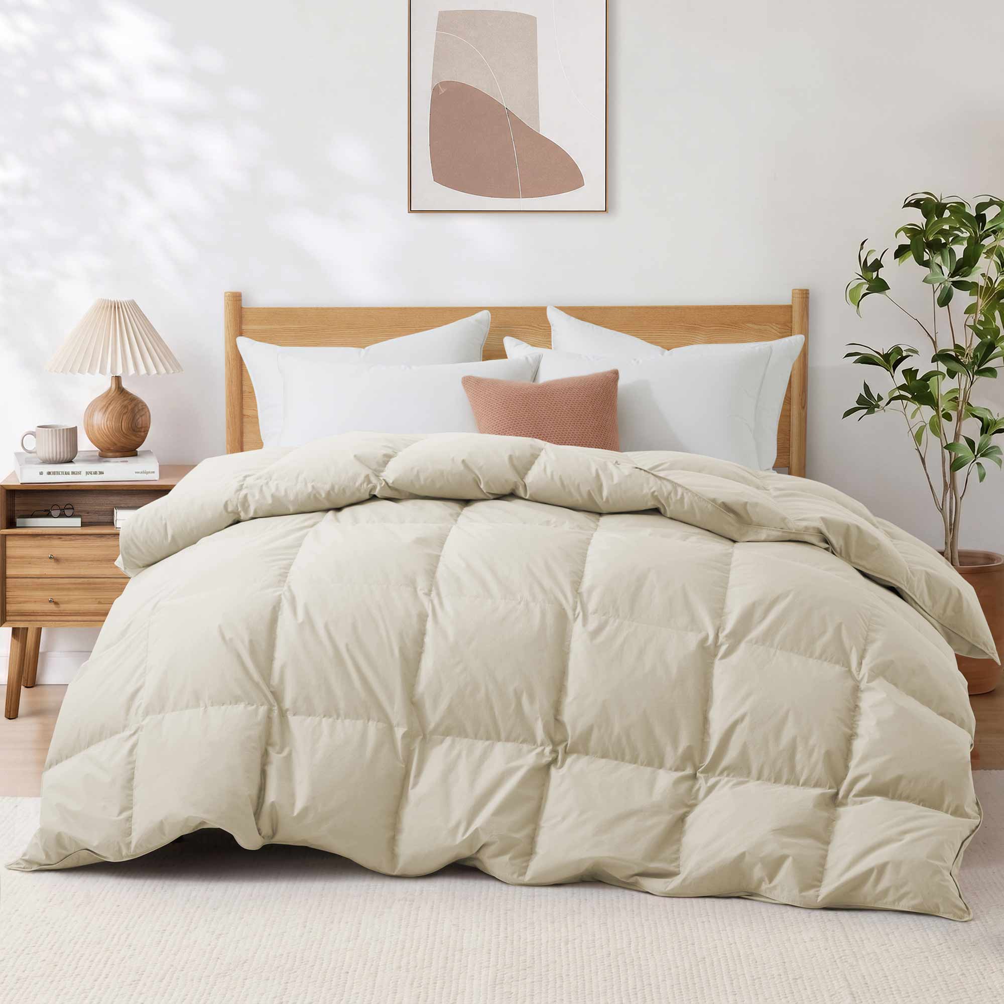 A neatly made bed featuring the Premium Goose Feather Comforter in beige, complemented by white pillows and wooden furniture in a cozy bedroom.