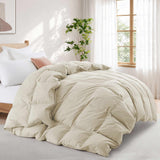 A Premium Goose Feather Comforter on the bed in a bright, cozy bedroom with a large window, a plant, and soft natural light.