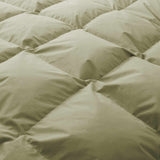 Close-up of the Premium Goose Feather Comforter in light green, featuring soft, puffy quilted square sections.