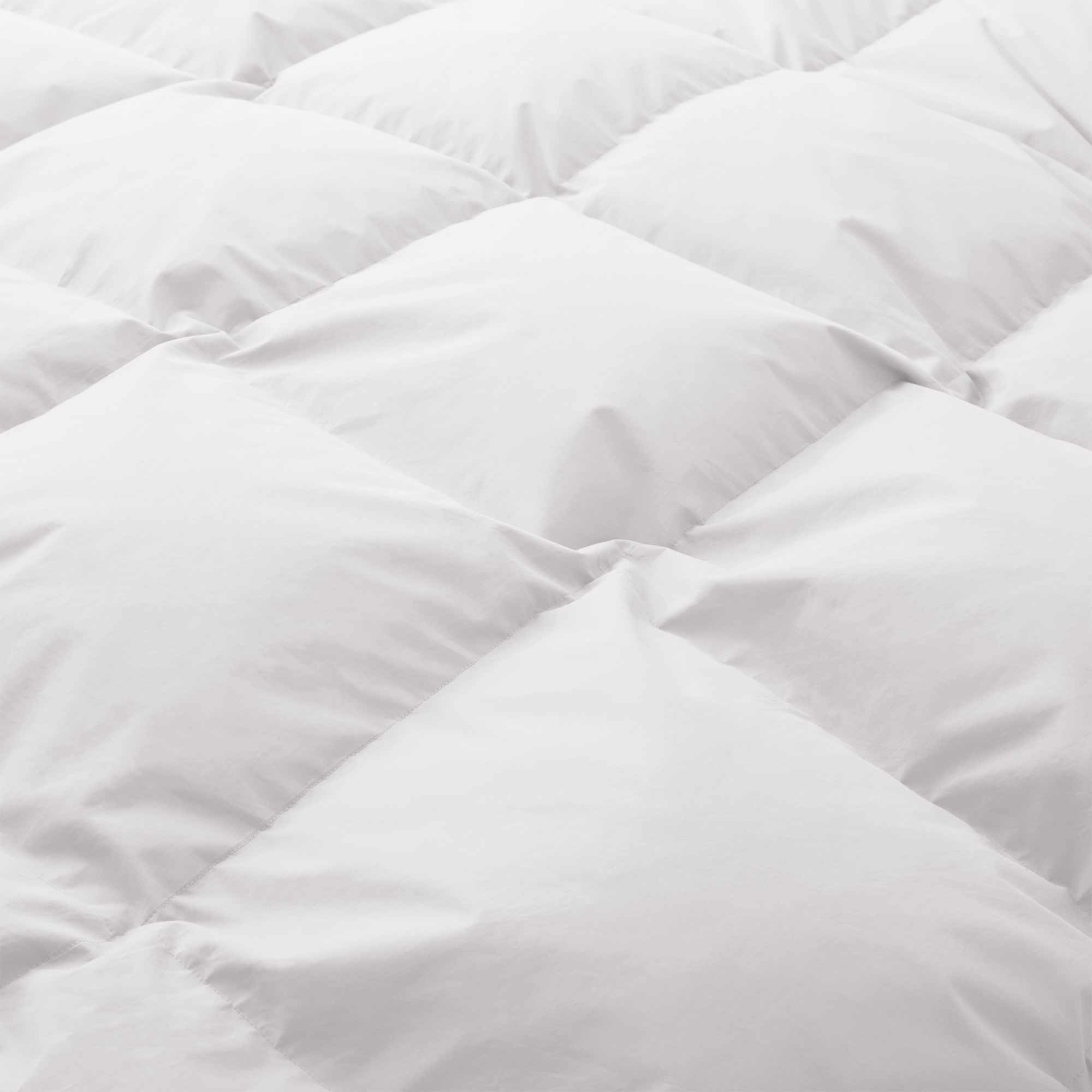 Close-up of the Premium Goose Feather Comforter, featuring a white, quilted design and a soft, puffy texture.