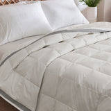 The twin down blanket is brushed in the soft tones of cloud white with a contrasting deep grey trim. Add a touch of elegance to your bedding with this cool blanket for summer in white.