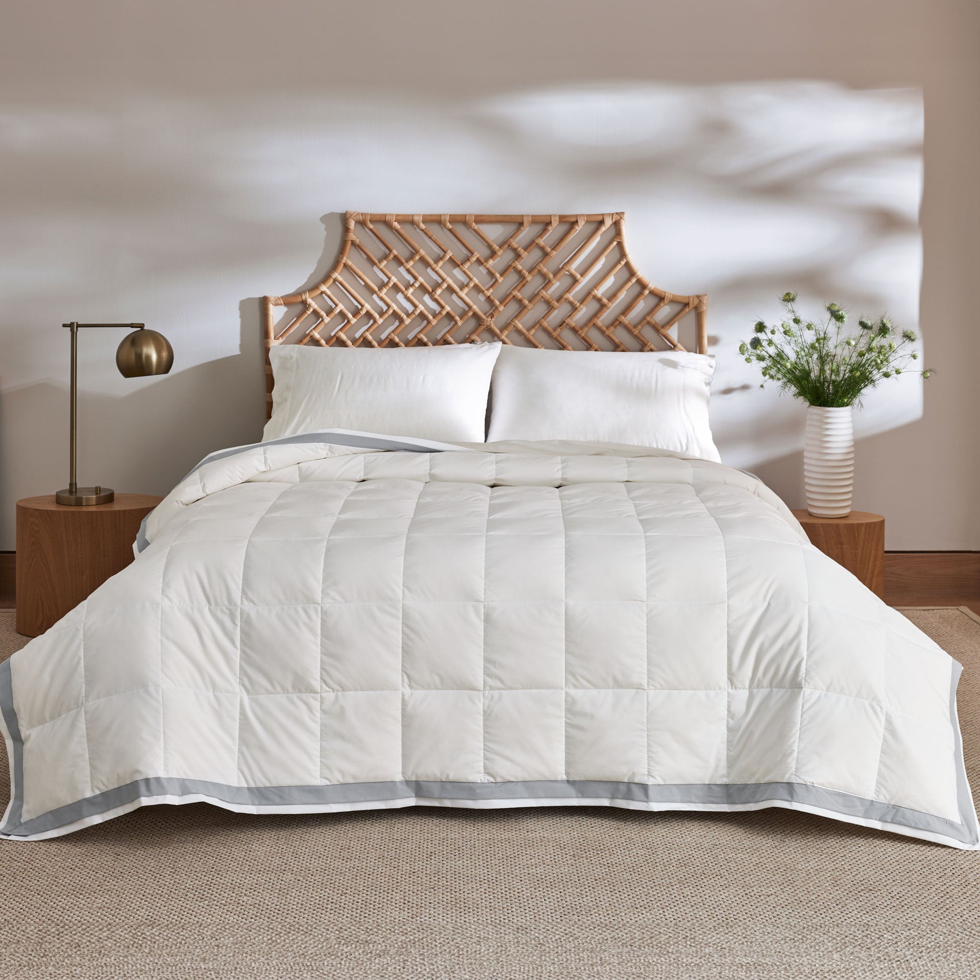 The twin down blanket is brushed in the soft tones of cloud white with a contrasting deep grey trim. Add a touch of elegance to your bedding with this cool blanket for summer in white.