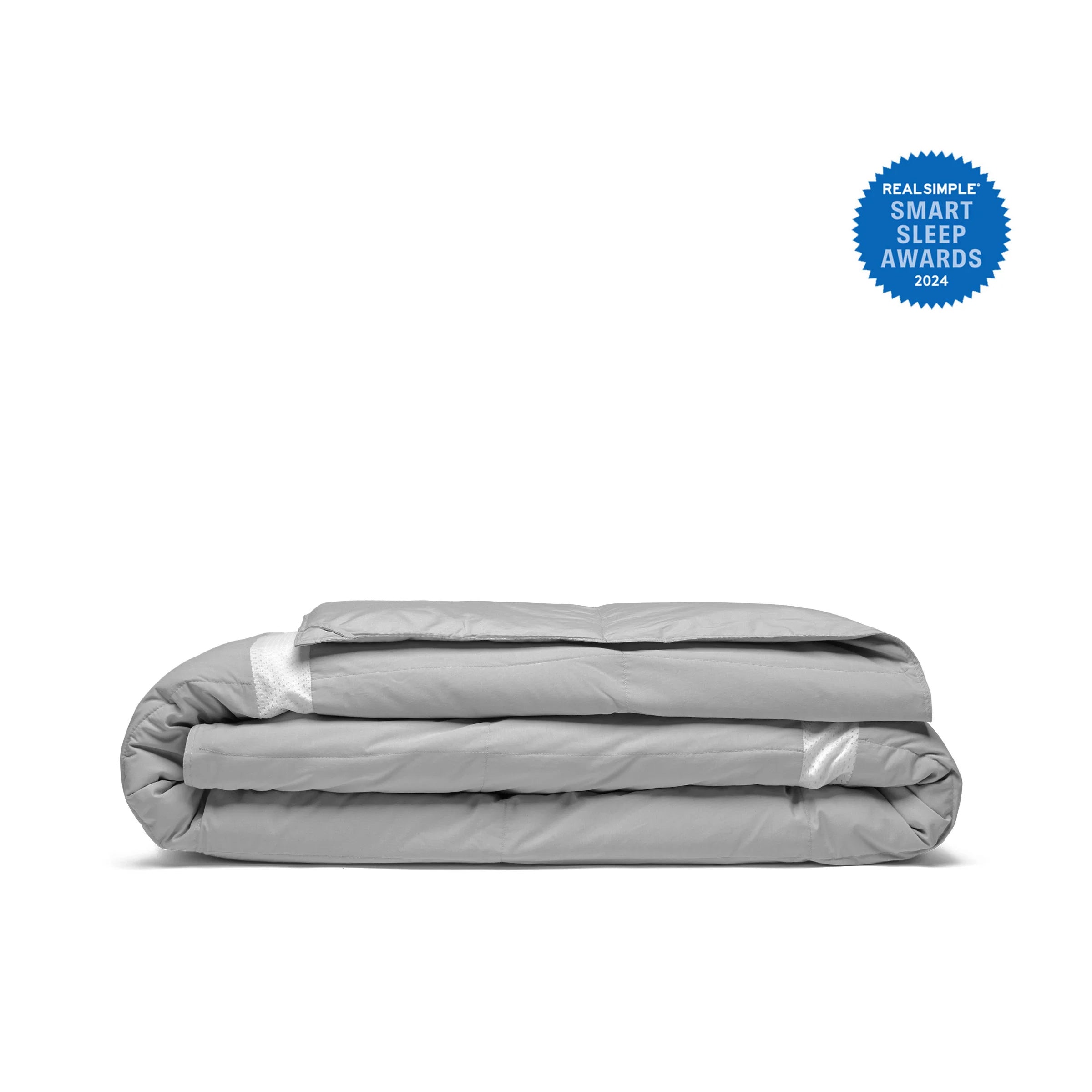 An Ultra Lightweight Cooling Down Comforter in a folded gray design, featuring a blue Real Simple Smart Sleep Awards 2024 badge in the top right corner.