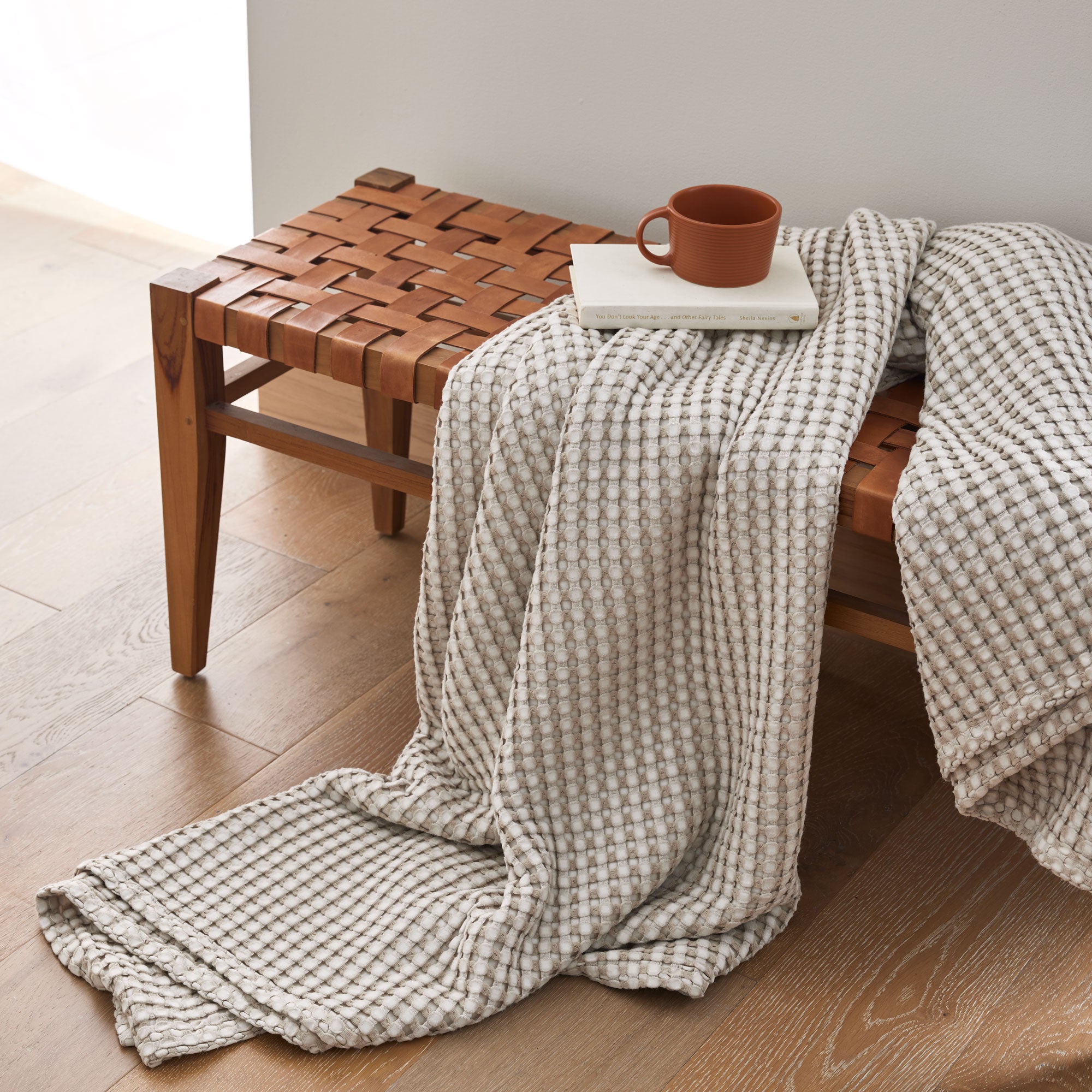 The all-weather blanket is covered in a beige color with soft camel undertones. Add a dimensional texture to your modern home décor with this perfectly pretty warm-season blanket for comfort.